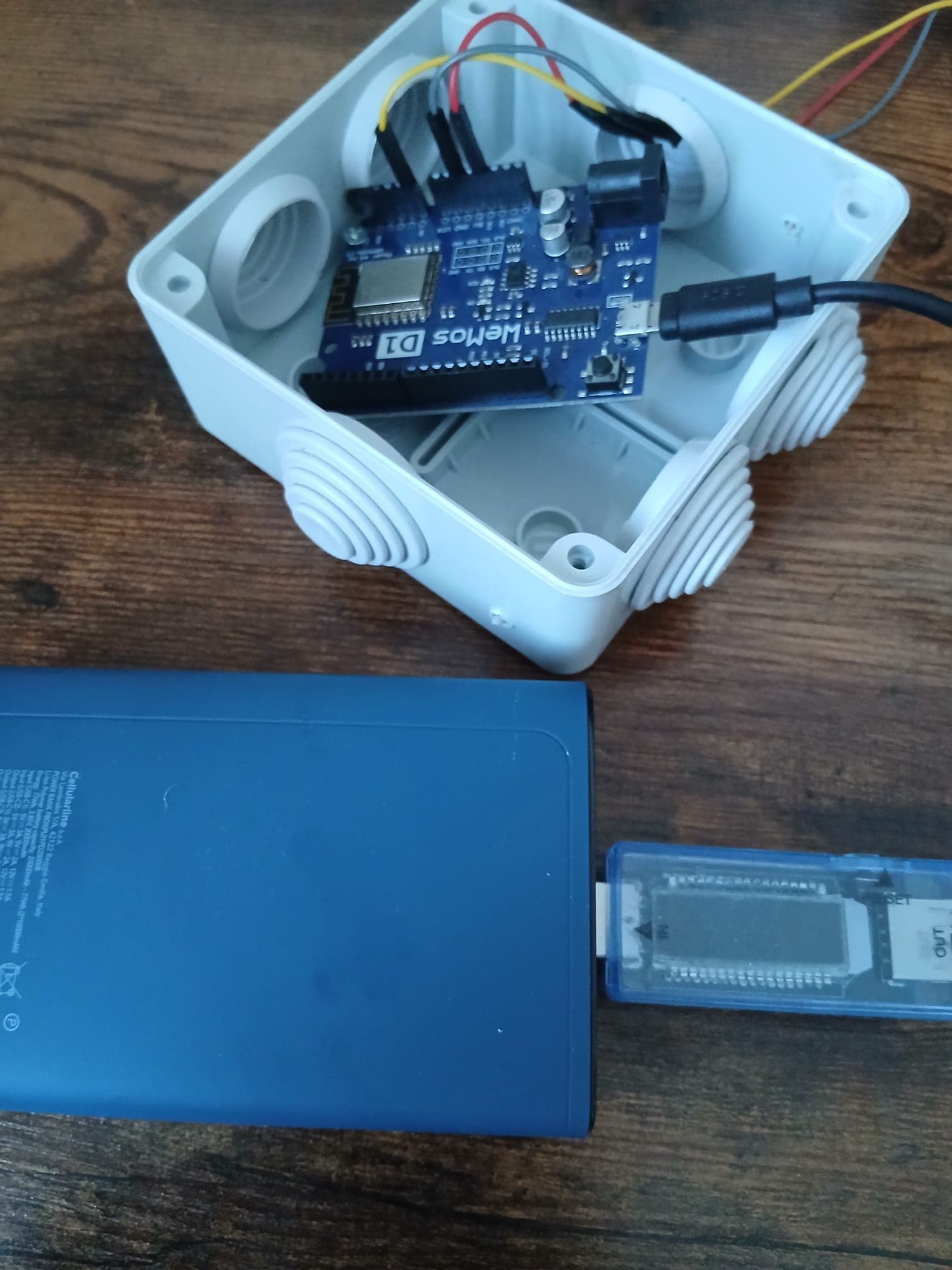 The same chain of power bank, USB meter and Wemos, but with the meter display dark and the board LED off.