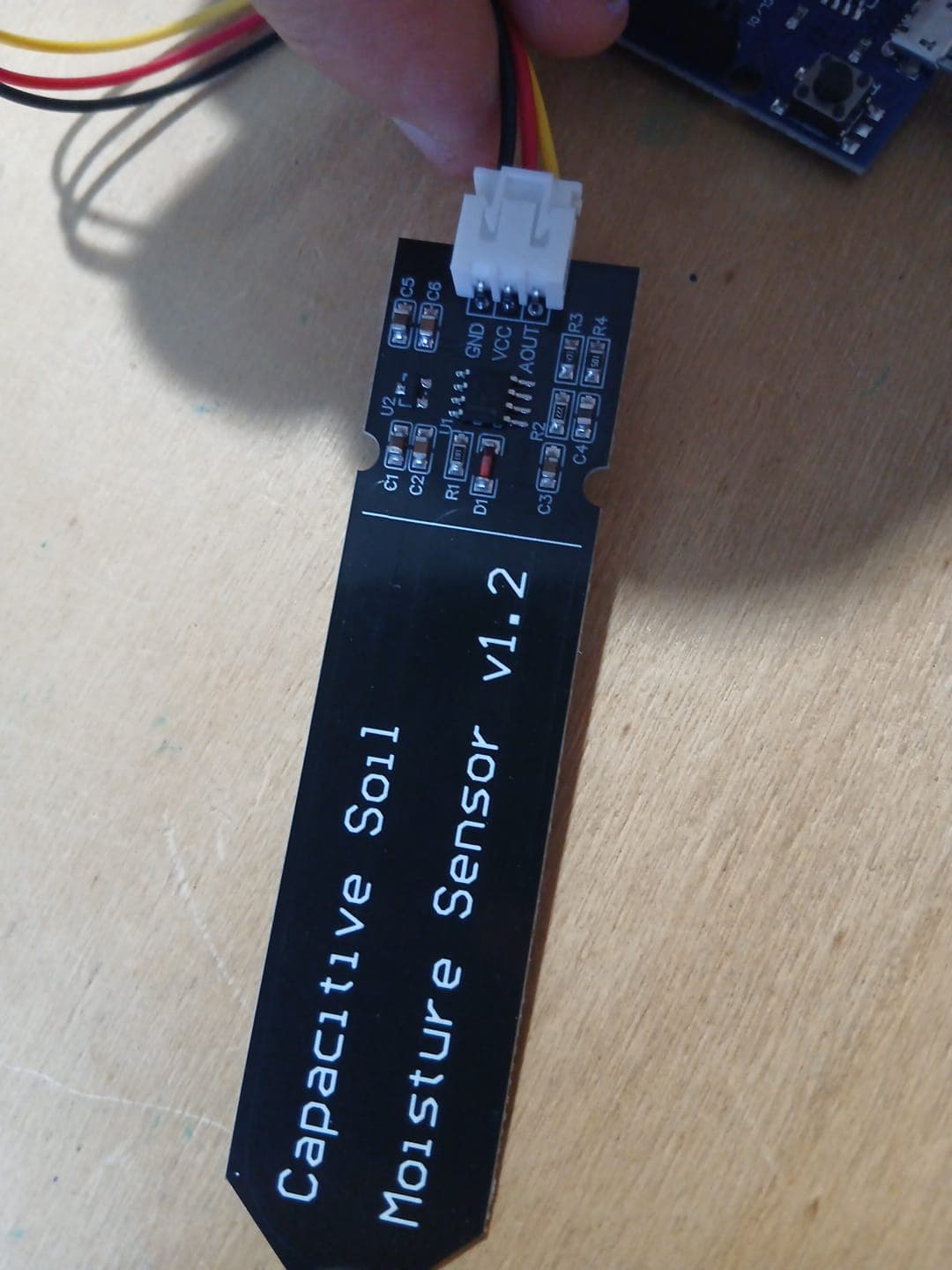 Close-up of the sensor's connector end, with the three pads labelled GND, VCC and AOUT.